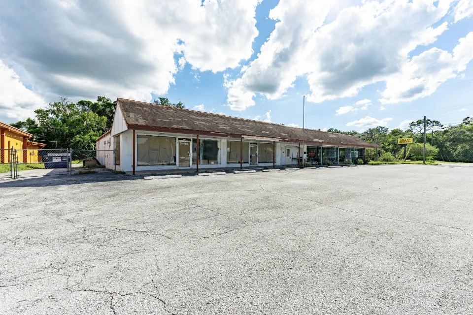 34480 Cortez Boulevard, a commercial storefront building with a large paved parking field in Ridge Manor, Florida.